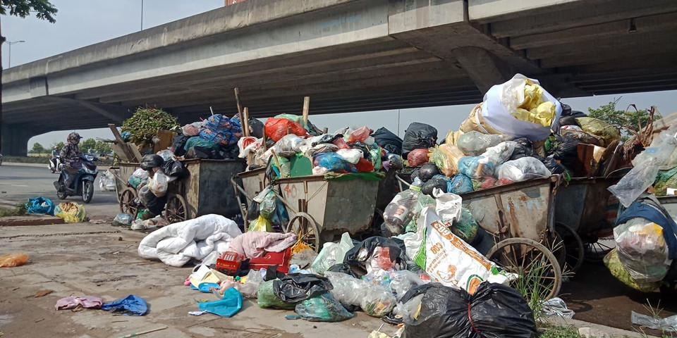 Hậu quả là rác thải sinh hoạt trong nội đô không được dọn dẹp, ngày càng đầy lên trên nhiều con phố, ảnh hưởng không nhỏ đến môi trường và mỹ quan đô thị. Trong ảnh, rác tập kết bên lề đường Nguyễn Xiển, Hà Nội. (Ảnh: Hùng Võ/Vietnam+)