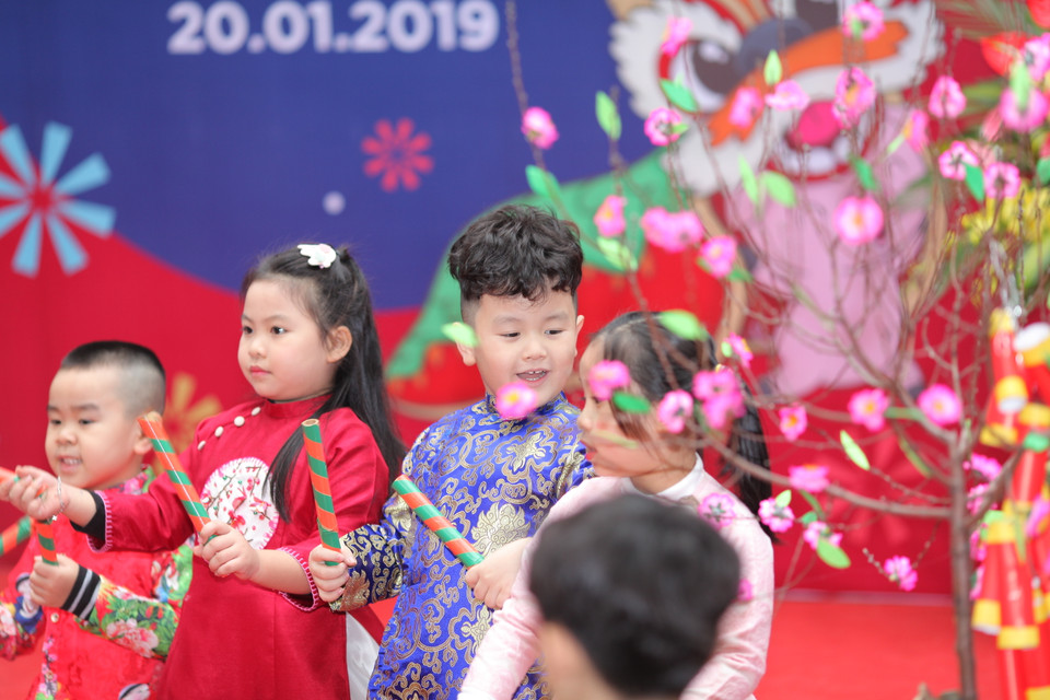 Ngày Tết đã đến rất gần, với áo dài khăn đống sắc màu, với hoa đào rực rỡ (Ảnh: PV/Vietnam+)