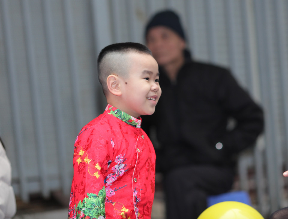 Những cổ động viên cũng xúng xính áo dài đỏ... (Ảnh: PV/Vietnam+)