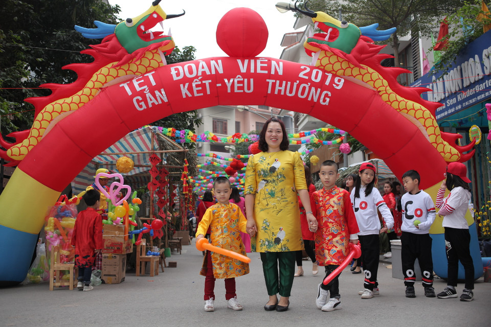 Học sinh, phụ huynh cùng xúng xính trong áo dài đón Tết. (Ảnh: PV/Vietnam+)