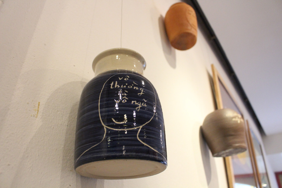 Những câu kinh Phật trên gốm, tranh của họa sỹ Lê Thiết Cương đều ngắn gọn, cô đọng, súc tích trong 4-5 chữ, người xem tùy ý cảm nhận, diễn giải tác phẩm theo trải nghiệm của cá nhân mình. (Ảnh: Minh Anh/Vietnam+)