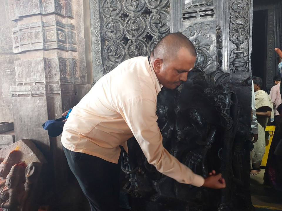 Hướng dẫn viên gõ vào phần ống sáo, tạo ra âm thanh trong trẻo. (Ảnh: Minh Thu/Vietnam+)