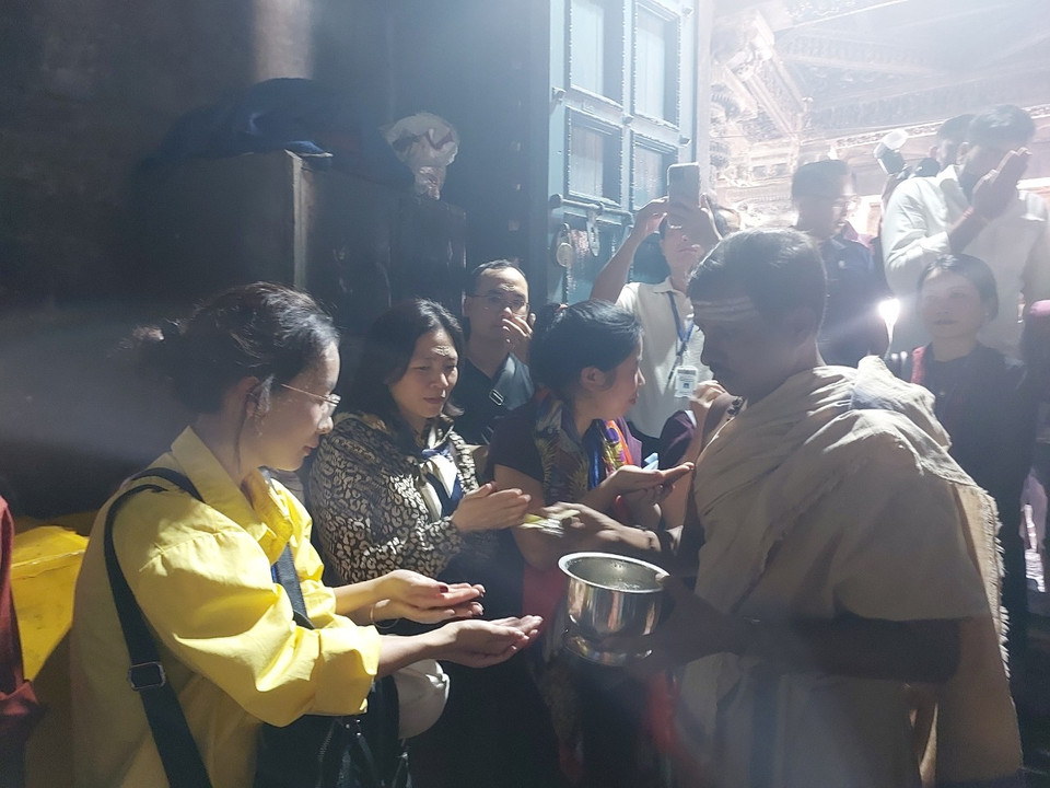 Khách tham quan chờ để được ban nước thiêng, nhận sự phù hộ của Thần Shiva. (Ảnh: Minh Thu/Vietnam+)