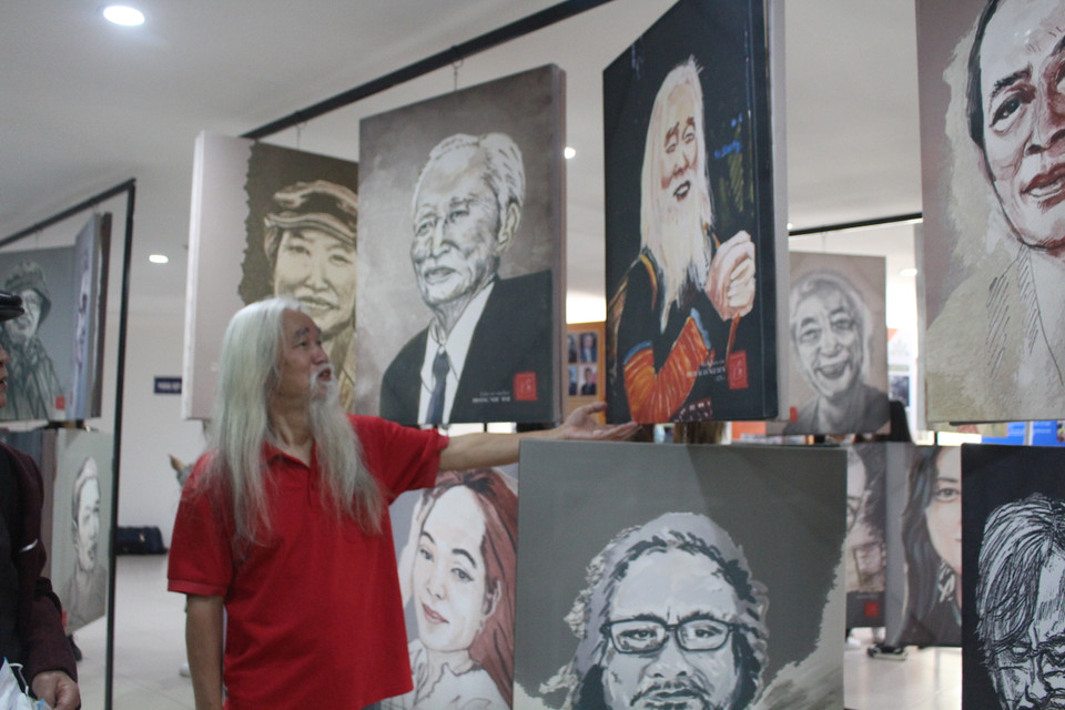 Tác giả mang đến triển lãm hai cụm tranh, gồm 100 trong tổng số 400 bức chân dung vẽ những người đồng nghiệp trong làng báo, các văn nghệ sỹ văn chương, nhiếp ảnh... và những bức áp phích cổ động chống dịch được in trên áo dài. (Ảnh: Minh Anh/Vietnam+)