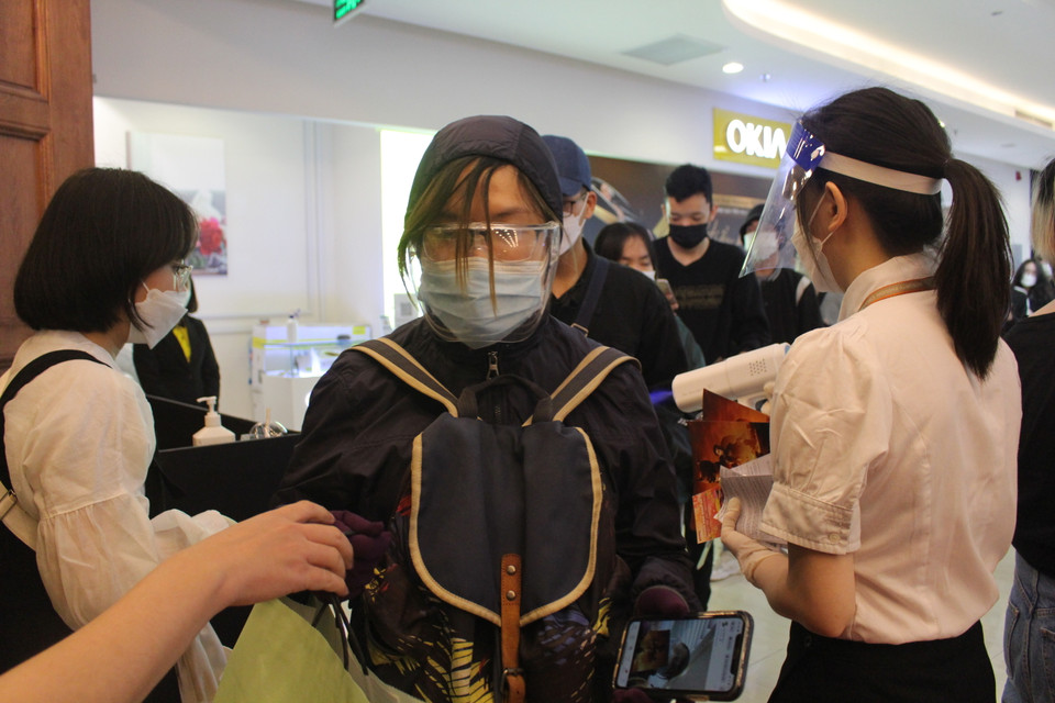 Một số người hâm mộ tự trang bị kính chắn giọt bắn cho bản thân khi đến sự kiện. (Ảnh: Minh Anh/Vietnam+)