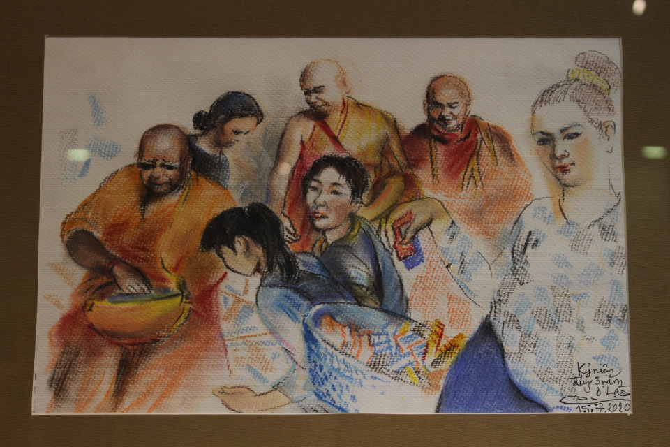 Bên cạnh Phật giáo, các hoạt động văn hóa, lễ hội cũng thường xuyên là chủ đề trong tranh của họa sỹ. Bức ''Lễ ngày rằm,'' họa sỹ được trải nghiệm những dịp ăn mừng ngày rằm kéo dài cả tuần thay vì chỉ một ngày như tại Việt Nam. Tác phẩm được vẽ ngày 15/7/2020, kỷ niệm dịp tròn 3 năm họa sỹ làm việc tại Lào. (Ảnh: Minh Anh/Vietnam+)