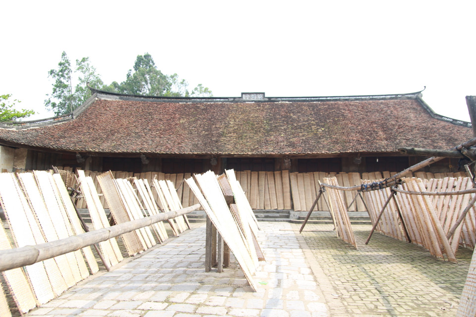 Những mẻ bánh đa trắng ngần phơi nắng bên mái đình cong cong. (Ảnh: Mai Hiền/Vietnam+)