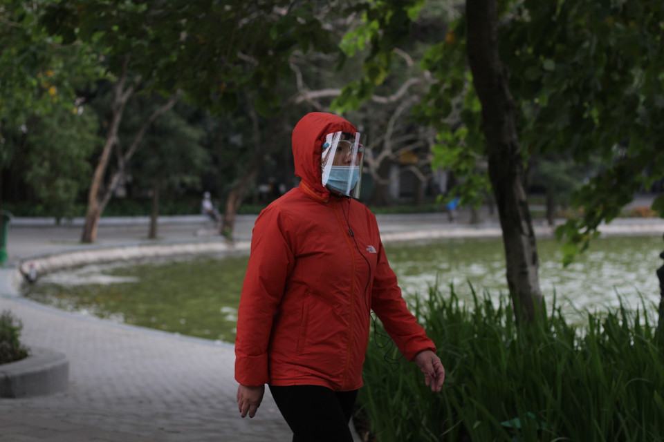 Người dân trang bị áo có mũ để bớt lạnh khi đi bộ ở khu vực nhiều gió. (Ảnh: Minh Anh/Vietnam+)