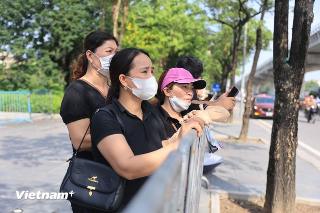 Càng về trưa, trời càng nắng nóng nhưng đoàn người vẫn trật tự, nghiêm trang xếp hàng khu vực rào chắn. (Ảnh: Hoài Nam/Vietnam+)