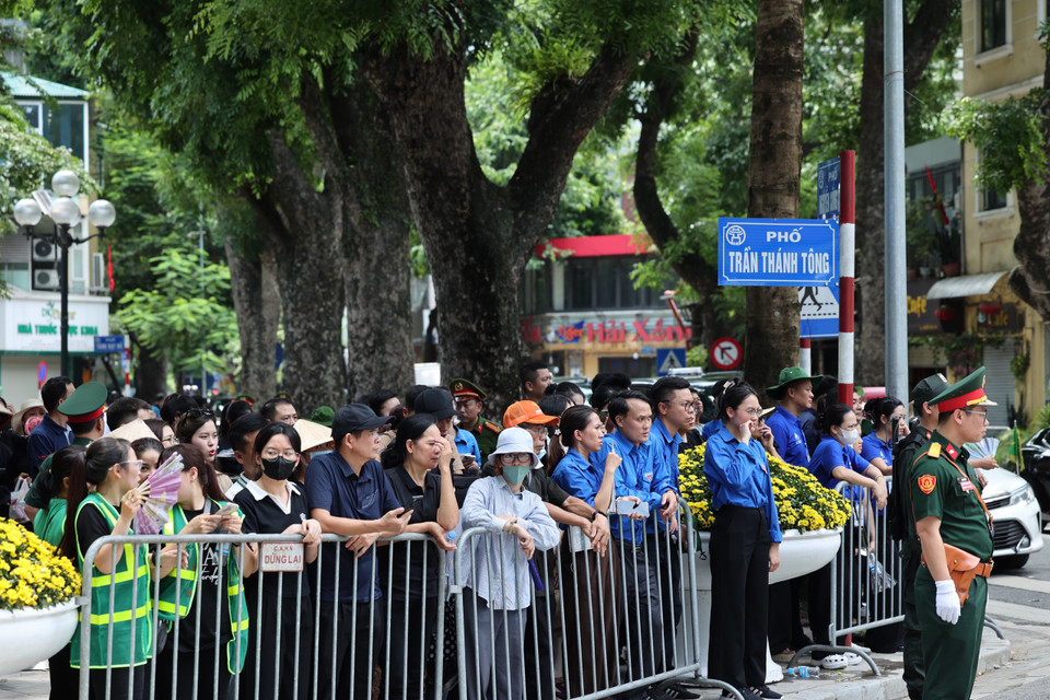 Người dân tập trung tại khu vực phố Trần Thánh Tông chờ đến giờ truy điệu. (Ảnh: Minh Sơn/Vietnam+)
