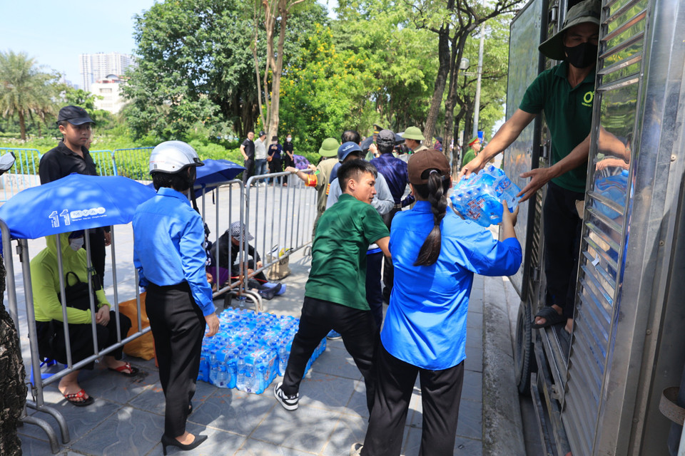 Các thanh niên tình nguyện vận chuyển nước uống để phục vụ người dân. (Ảnh: Hoài Nam/Vietnam+)