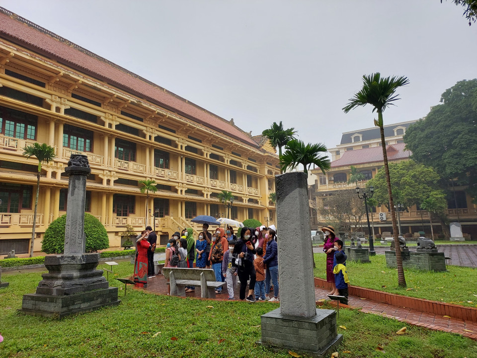 Đoàn khách tham quan đang lắng nghe cán bộ bảo tàng thuyết minh về cụm bảo vật quốc gia. (Ảnh: Minh Thu/Vietnam+)