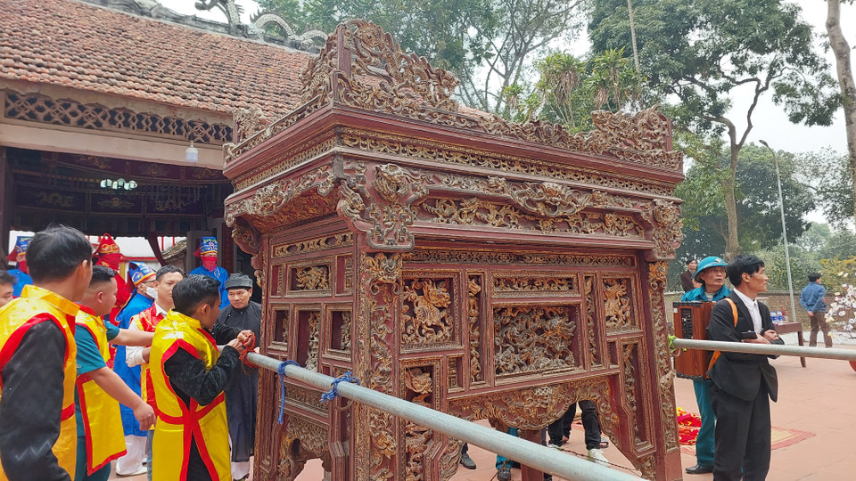  Lễ rước kiệu được tiến hành từ 12h30 ngày 12 tháng Giêng. Trên kiệu là các sắc phong, bài vị, quả Phết được cất giữ trong cung cấm của đình làng từ ngày mùng 10/10 Âm lịch. Kiệu được khiêng từ đình ra đền do các binh sỹ hộ tống. (Ảnh: Minh Thu/Vietnam+)