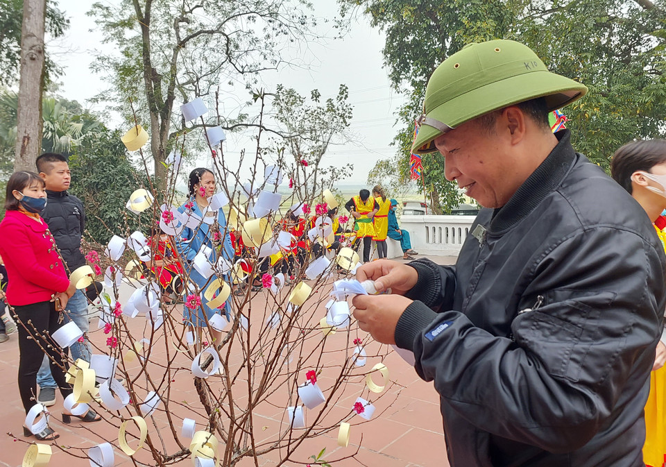 Người dân dự hội có thể hái câu đối rồi nhờ các cụ cao niên giảng giải để xem vận may trong năm. (Ảnh: Minh Thu/Vietnam+)