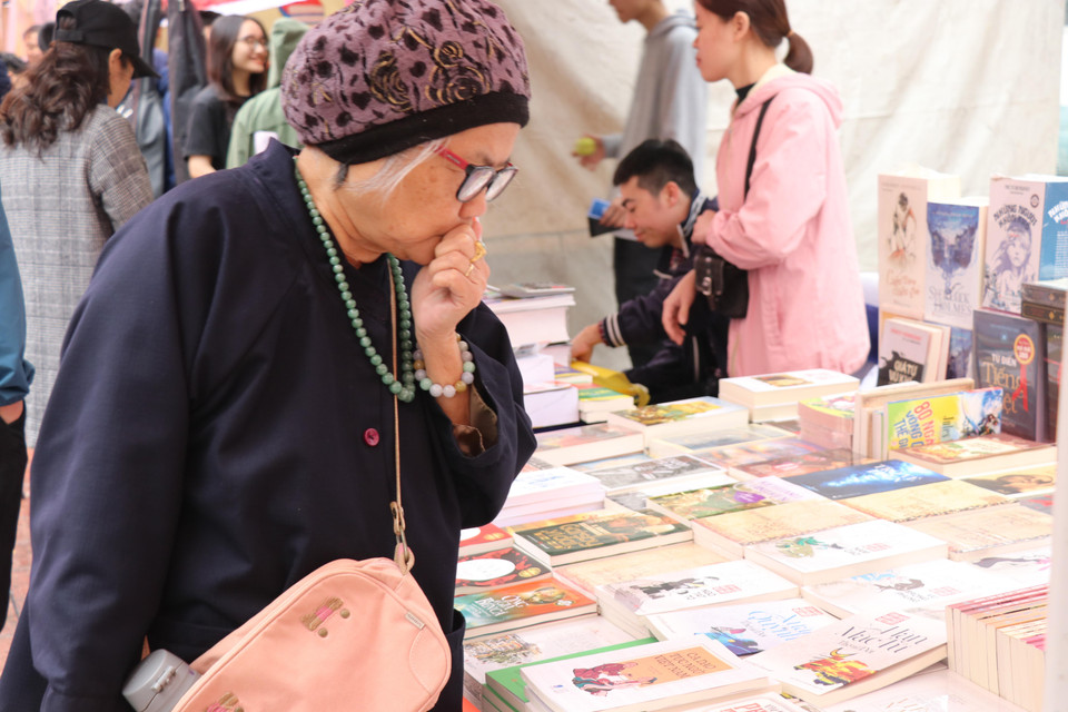 cũng chăm chú chọn lựa sách. (Ảnh: PV/Vietnam+)