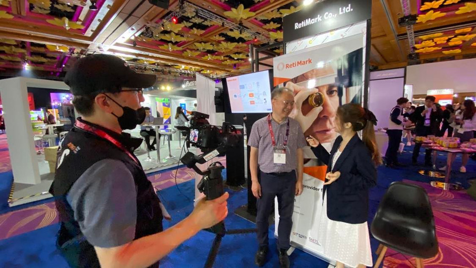 Báo chí phỏng vấn đại diện RetiMark, đơn vị chuyên về giải pháp cho bệnh thoái hóa điểm vàng ở mắt. (Ảnh: Minh Thu/Vietnam+)