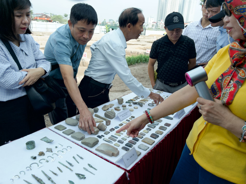 Các chuyên gia xem xét các hiện vật tìm thấy ở di chỉ. (Ảnh: Phương Anh/Vietnam+)