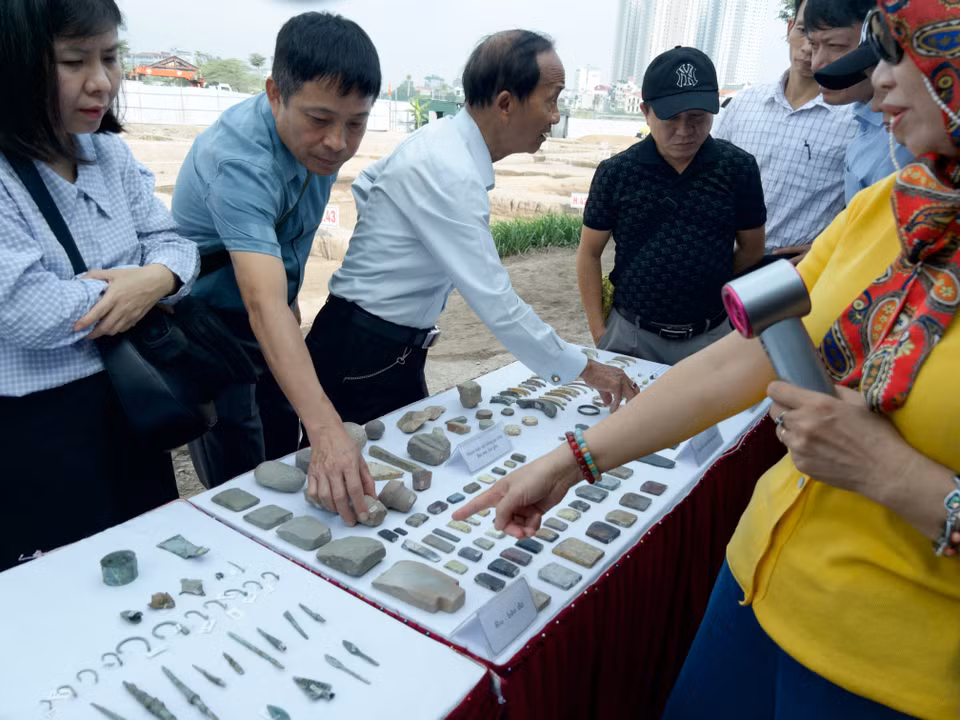 Các chuyên gia xem xét các hiện vật tìm thấy ở di chỉ. (Ảnh: Phương Anh/Vietnam+)
