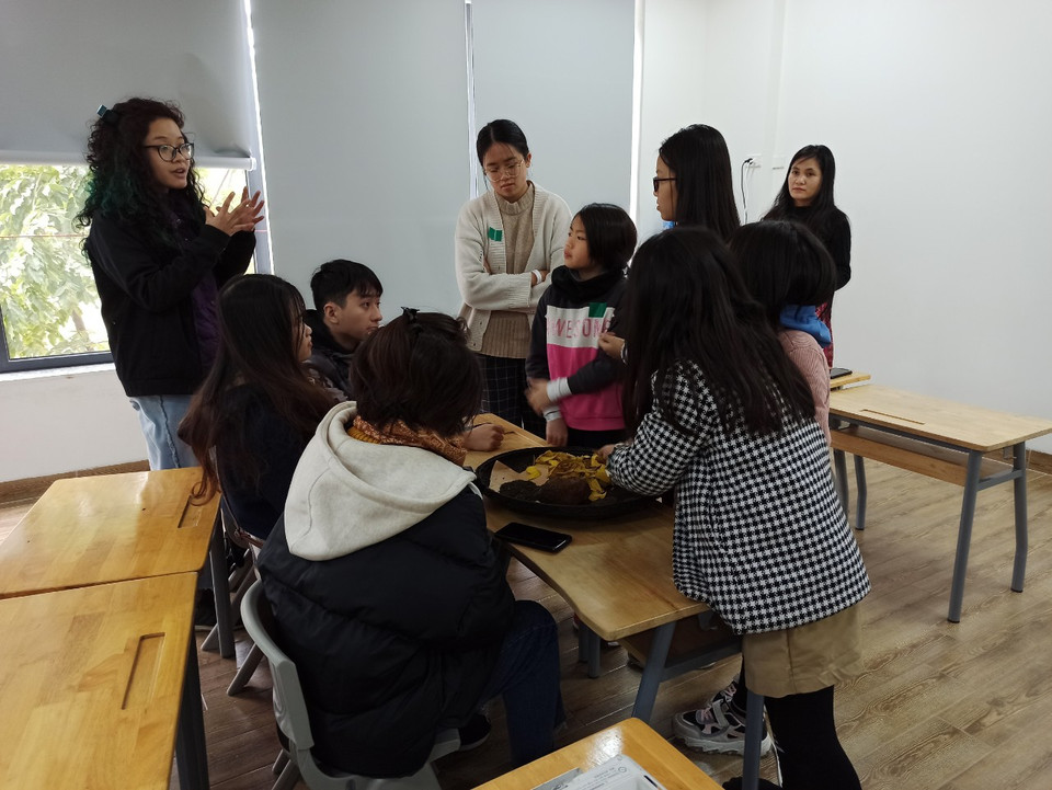 Một nhóm học sinh say sưa nghe nghệ nhân giới thiệu về hoạt động nhuộm vải của đồng bào dân tộc thiểu số. (Ảnh: PM/Vietnam+)