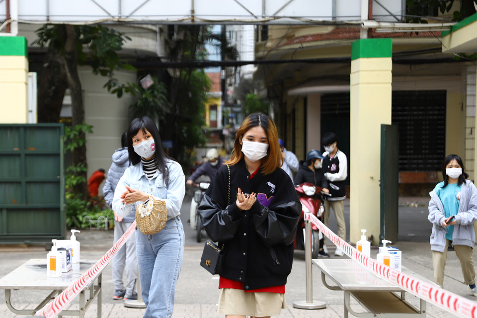 Thực hiện đo thân nhiệt và khử khuẩn trước khi vào trường. (Ảnh: Hoài Nam/Vietnam+)