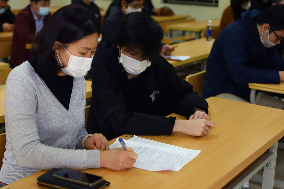 Giáo viên chủ nhiệm hướng dẫn học sinh khai báo theo đúng mẫu. (Ảnh: Hoài Nam/Vietnam+)