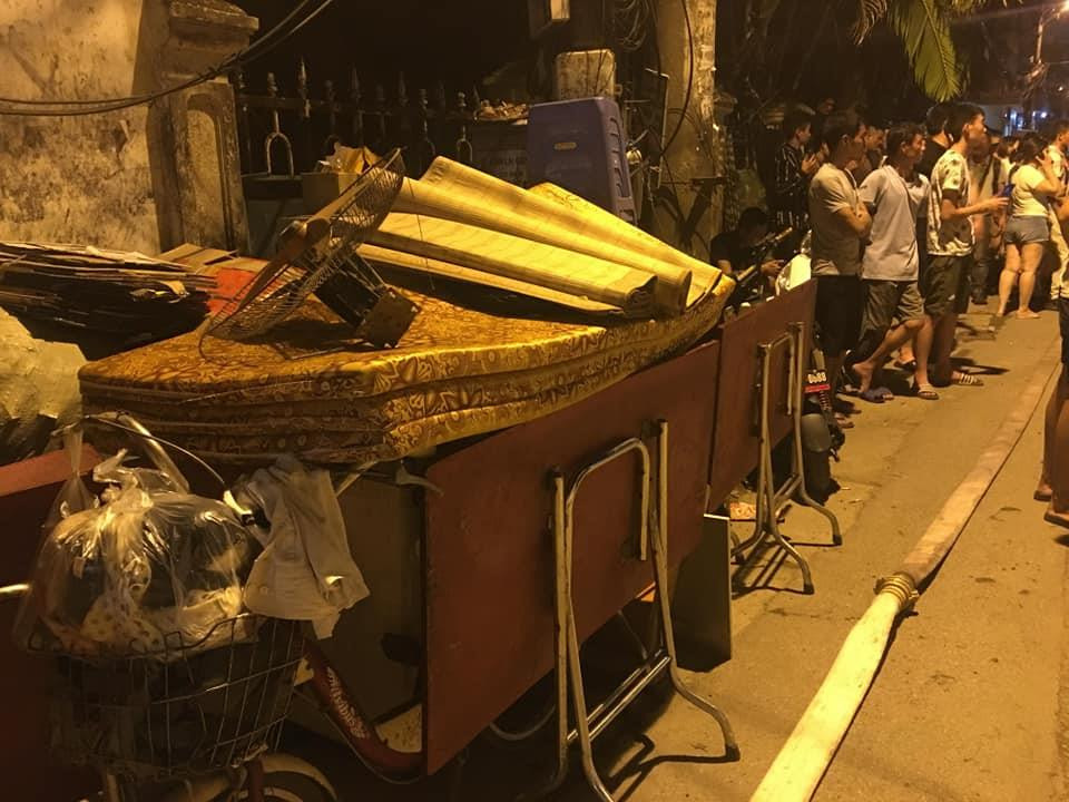 Khoảng 20 giờ, đám cháy ở xưởng của Công ty Bóng đèn phích nước Rạng Đông lan rộng sang nhà dân ở mặt phố Hạ Đình (Thanh Xuân, Hà Nội). Nhiều người gọi nhau chuyển đồ đạc trong nhà ra ngoài. (Ảnh: Sơn Bách/Vietnam+)