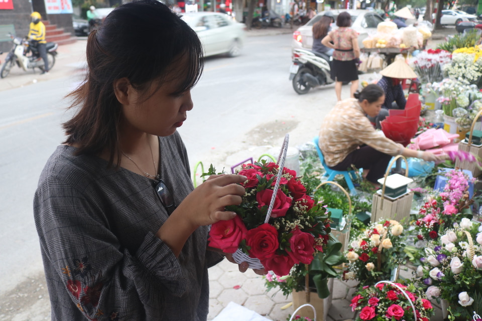 Khách hàng cẩn thận lựa chọn những bông hoa tươi thắm nhất để dành tặng các thầy, cô giáo. (Ảnh: Lương Mạnh/Vietnam+)