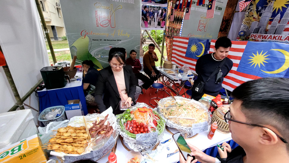 Gian hàng Malaysia giới thiệu một số món như bún xào trứng, nộm đu đủ, gà xiên, bò xiên... (Ảnh: Minh Anh/Vietnam+)