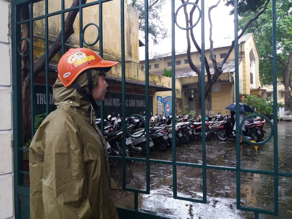 Sốt ruột ngóng con từ cổng trường. (Ảnh: Phạm Mai/Vietnam+)