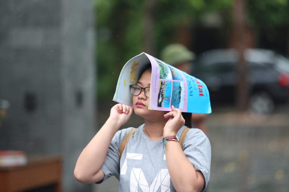 Atlat Địa lý trở thành công cụ hữu hiệu để tránh mưa. (Ảnh: Sơn Bách/Vietnam+)