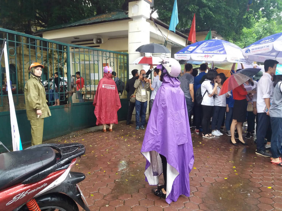 Sốt ruột ngóng con từ cổng trường. (Ảnh: Phạm Mai/Vietnam+)