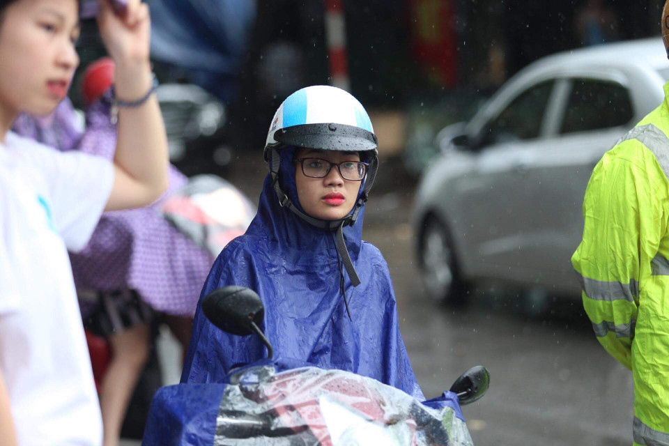 Khi giờ thi còn chưa kết thúc, rất nhiều phụ huynh đã đội mưa đứng đợi con trước cổng trường. Ảnh chụp tại trường Trung học phổ thông Amsterdam. (Ảnh: Sơn Bách/Vietnam+)