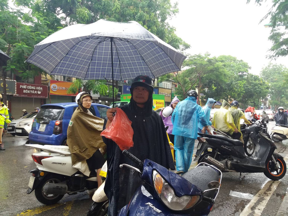 Một phụ huynh đứng chờ con trước cổng trường Trung hoc phổ thông Việt Đức. (Ảnh: Phạm Mai/Vietnam+)