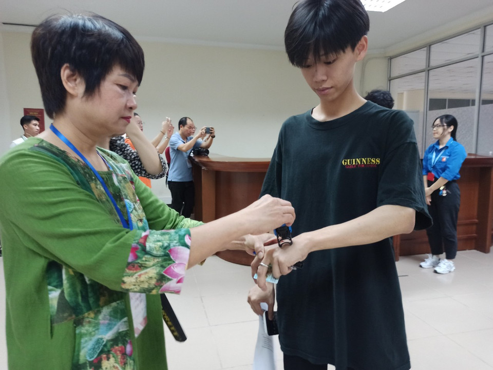 Sau vòng kiểm tra thiết bị, thí sinh sẽ được đóng dấu xác nhận đã kiểm tra. (Ảnh: PM/Vietnam+)