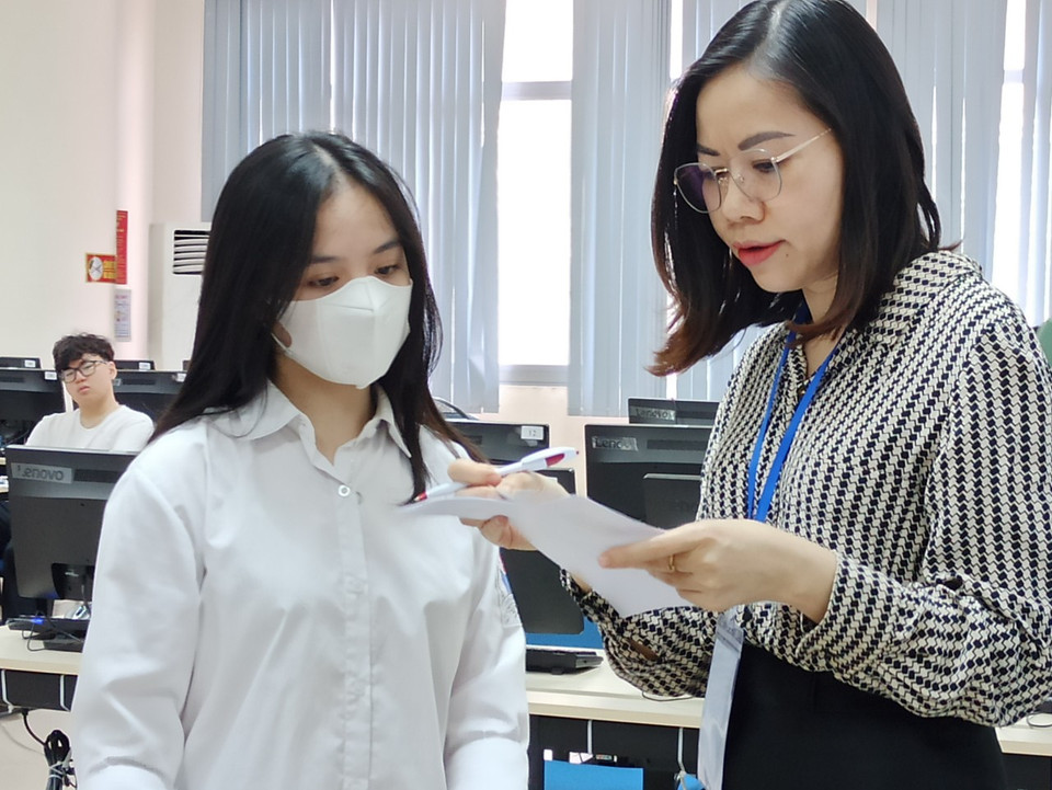 Trước khi vào phòng thi, các em tiếp tục được kiểm tra thông tin một lần nữa bởi các cán bộ coi thi. (Ảnh: PM/Vietnam+)