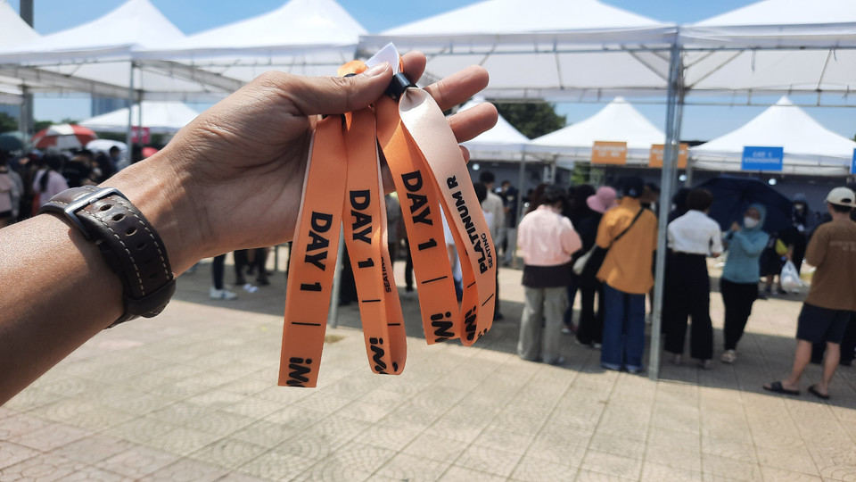  Mặc dù có một vài sự cố, nhưng người hâm mộ vẫn rất háo hức xếp hàng chờ đến lượt. Khi nhận vòng ai nấy đều cảm thấy rất vui và phấn khích, mọi sự chờ đợi đều là xứng đáng. (Ảnh: PV/Vietnam+) 