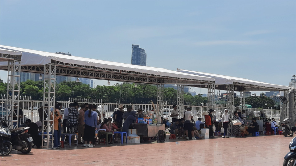 Nhiều khán giả và người bán hàng chen chân trong những khu vực bóng râm để tránh nóng. (Ảnh: PV/Vietnam+)