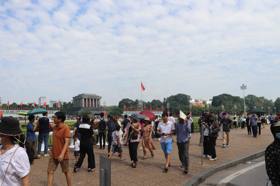 Xung quanh khu vực này, tuyến đường Độc Lập đông đúc cả hai bên vỉa hè lẫn lòng đường. Lượng xe máy, ôtô cá nhân ồ ạt đổ về, muốn dừng lại chụp ảnh. Lực lực cảnh vệ lăng phải làm việc liên tục để hạn chế tối đa việc dừng đỗ trái phép. (Ảnh: Minh Anh/Vietnam+)