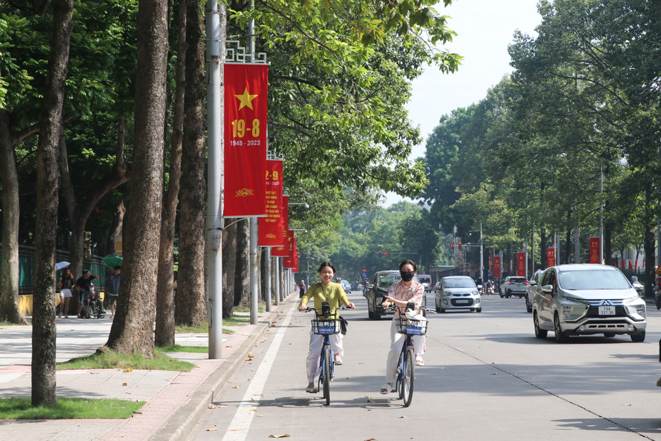 Bên cạnh những tuyến đường và khu vực đông đúc, phần lớn các tuyến khác vắng hơn do có một lượng dân cư về quê nghỉ lễ. Nữ giới kết hợp áo dài với xe đạp, thong thả trên những cung đường thênh thang của Hà Nội tạo khung cảnh vừa nên thơ, vừa thư giãn. (Ảnh: Minh Anh/Vietnam+)