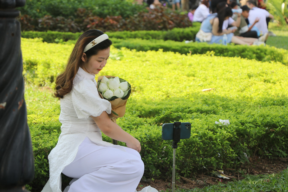 Mỗi người đều muốn lưu trữ lại những hình ảnh đẹp nhất của mình trong ánh nắng vàng ruộm. (Ảnh: Minh Anh/Vietnam+)