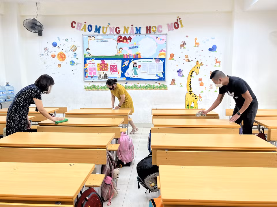 Giáo viên, phụ huynh phối hợp lau dọn bàn ghế tại Trường Tiểu học Kim Đồng. (Ảnh: PV/Vietnam+)