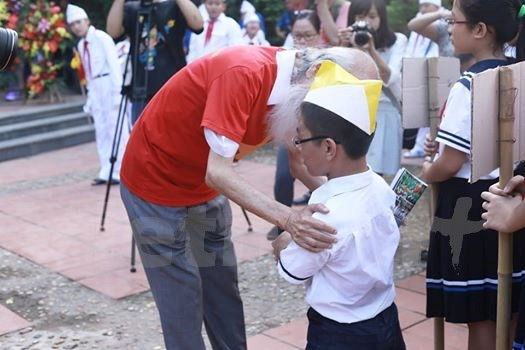Ông luôn quan tâm đến đời sống tinh thần của học sinh, từ việc nhỏ như ân cần đón học sinh mới (lớp 6) vào trường trong ngày khai giảng. (Ảnh: Tùng Lâm/Vietnam+)