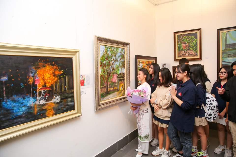 Có nhiều tác phẩm ấn tượng nhưng Trần Khánh Linh (15 tuổi, áo trắng) từng thấy khó khăn khi phải vẽ, nghĩ rằng nghệ thuật không phải điểm mạnh của mình. (Ảnh: Minh Sơn/Vietnam+)