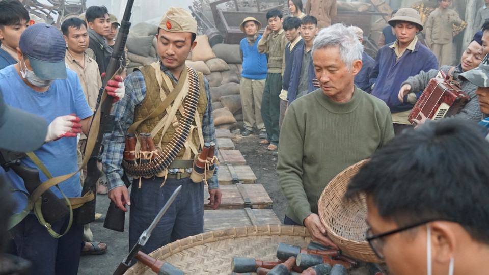 Nghệ sỹ Ưu tú Phi Tiến Sơn (tóc trắng) trên phim trường, ông vừa đảm nhiệm vị trí đạo diễn, vừa chắp bút cho kịch bản phim. (Ảnh: ĐPCC)