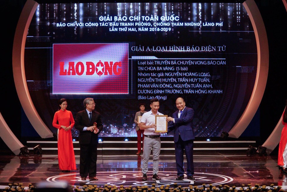 Thủ tướng Nguyễn Xuân Phúc và Thường trực Ban Bí thư Trần Quốc Vượng trao giải A cho đại diện nhóm tác giả của loạt bài 'Truyền bá chuyện vong báo oán tại chùa Ba Vàng.'(Ảnh: Minh Hiếu/Vietnam+)