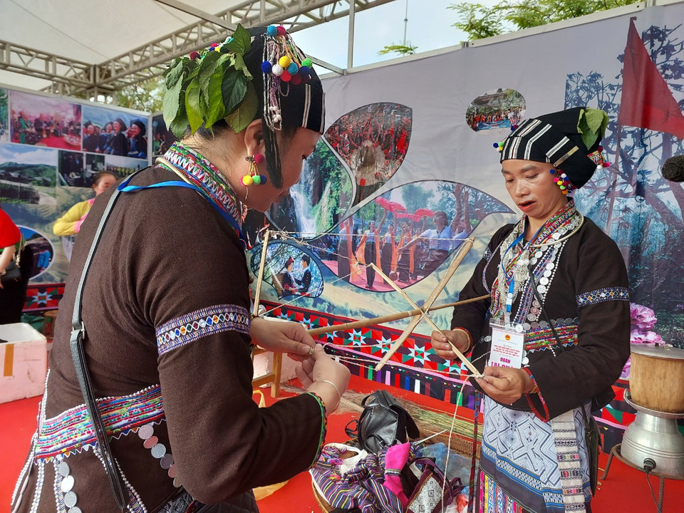 Hai người phụ nữ dân tộc Lự trong trang phục lễ hội đính nhiều trang sức cầu kỳ. (Ảnh: Minh Thu/Vietnam+)