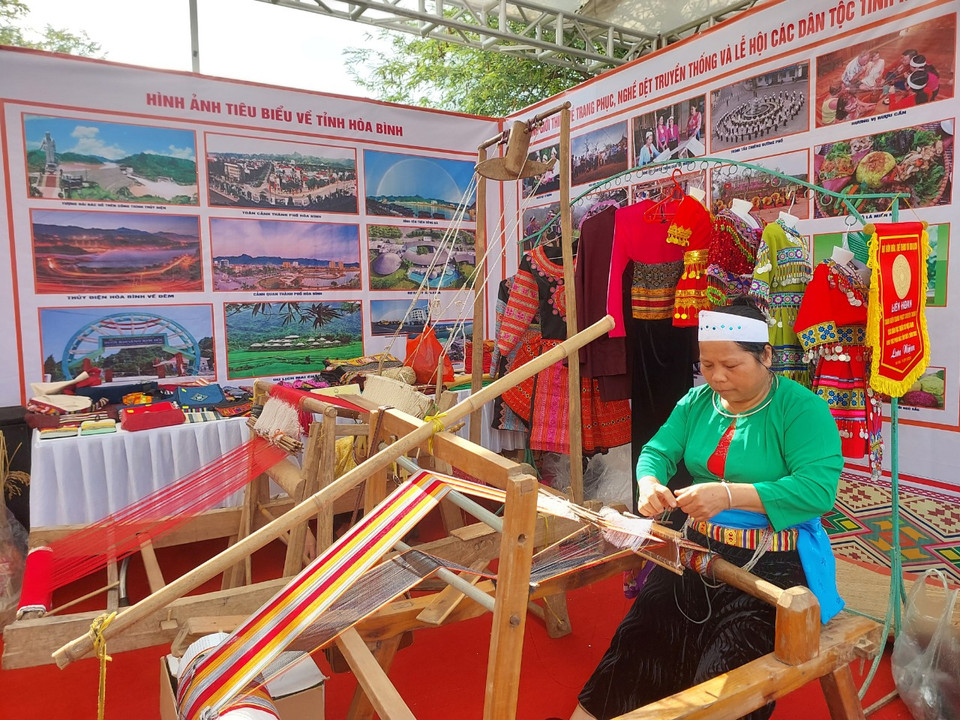 Phụ nữ dân tộc Mường, tỉnh Hòa Bình trình diễn kỹ năng dệt vải ngay tại gian hàng. (Ảnh: Minh Thu/Vietnam+)