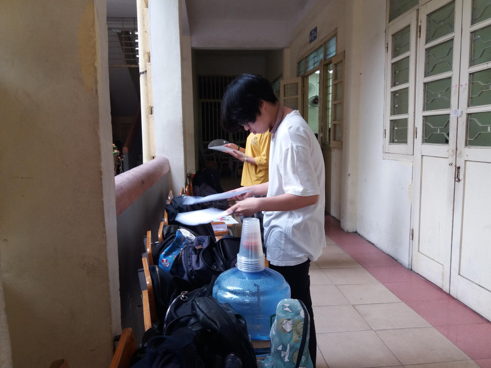 Thí sinh chuẩn bị các vật dụng để mang vào phòng thi. (Ảnh: PM/Vietnam+)