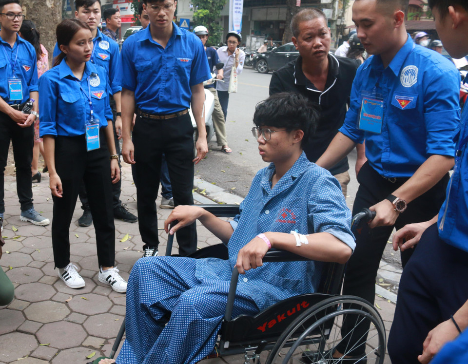 Thí sinh Nguyễn Mạnh Tân là học sinh Trường Trung học phổ thông Trần Phú (Hoàn Kiếm, Hà Nội). Tân vừa trải qua ca phẫu thuật mổ ruột thừa ngày 23/6. Do sức khỏe chưa hồi phục nên em phải đến điểm thi bằng xe lăn. (Ảnh: Nguyễn Hoàng/Vietnam+)
