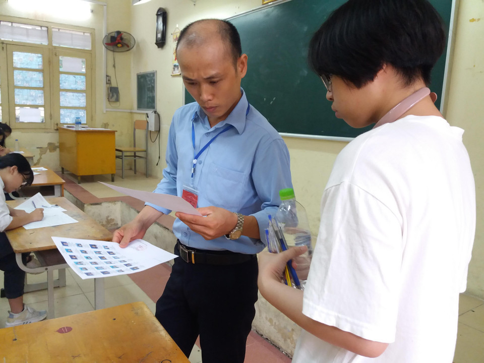 Và cẩn thận đối chiếu khuôn mặt, thông tin cá nhân. (Ảnh: PM/Vietnam+)